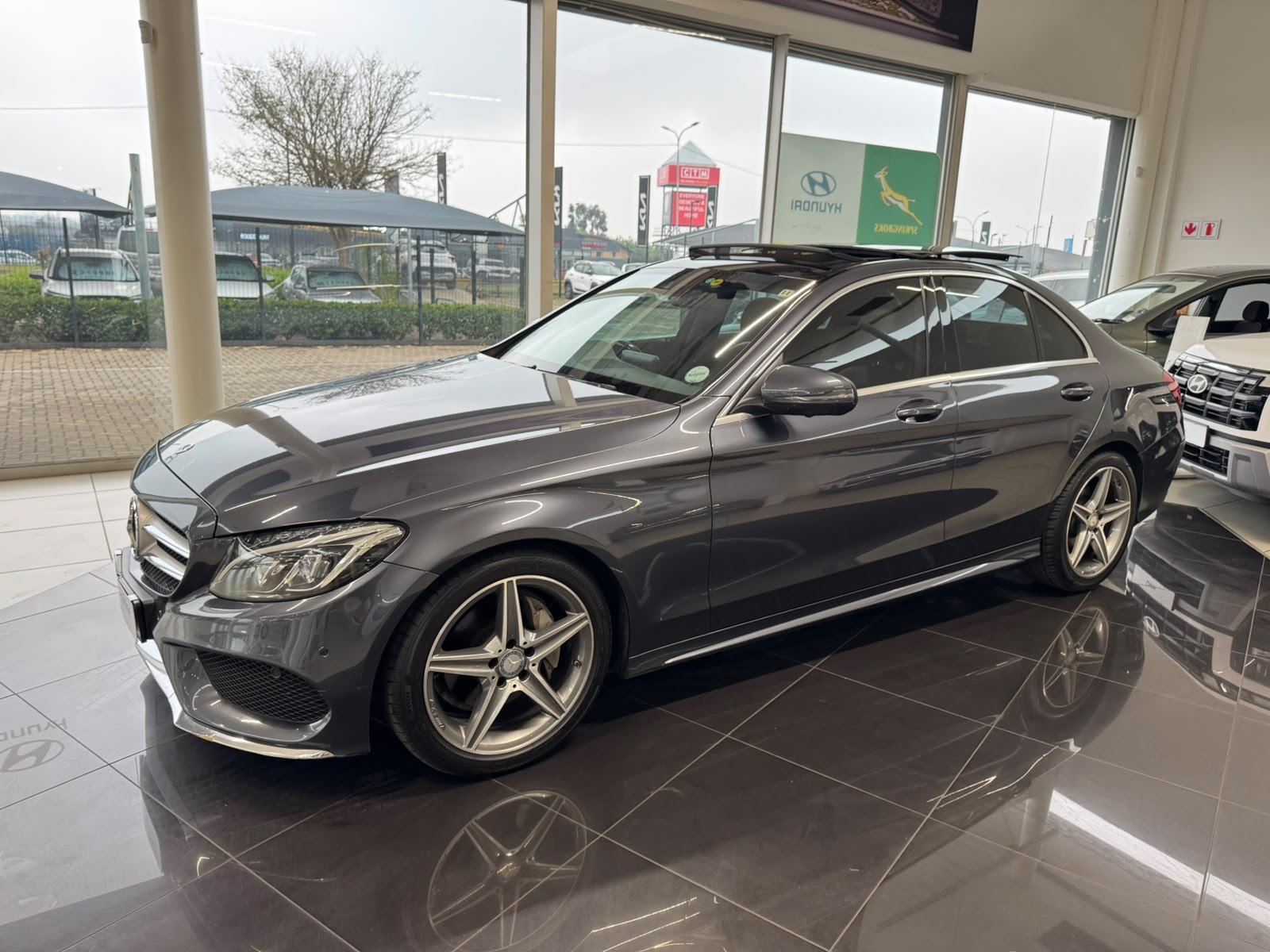 Grey Mercedes-Benz C-Class side view in showroom